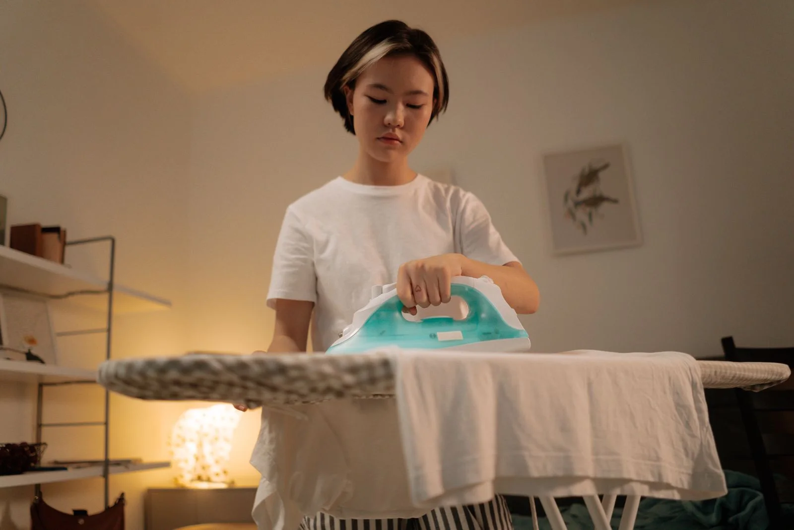 Perempuan menyetrika pakaian - foto stok ilustratif, bukan staf atau lokasi Bening Laundry